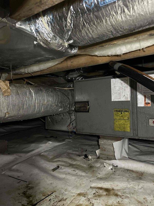 Responded to no cooling call on 15-year-old electric heat pump system with no airflow from indoor unit located in crawlspace. Upon arrival, confirmed thermostat was receiving power but blower motor was not operating. Performed diagnostic inspection of air handler and verified no tripped breakers, refrigerant line icing, or obvious electrical issues at disconnect. Accessed crawlspace unit and tested system components. Measured supply air temperature at ductwork registering 57.5°F, indicating compromised system performance. Blower motor failure identified as root cause of no airflow condition, requiring replacement to restore system operation.