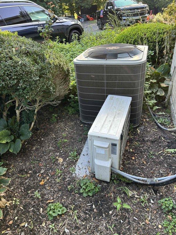 Completed Gold Level prepaid maintenance on a two-system residential HVAC setup consisting of a heat pump/air handler, mini-split unit located in attic and crawl space, and outdoor condenser unit. Replaced customer-supplied 20x25x4 air filters across the systems and performed comprehensive system inspection and maintenance procedures. Documented equipment condition with photos showing the cylindrical outdoor condenser unit in landscaped area and the three replaced pleated air filters.