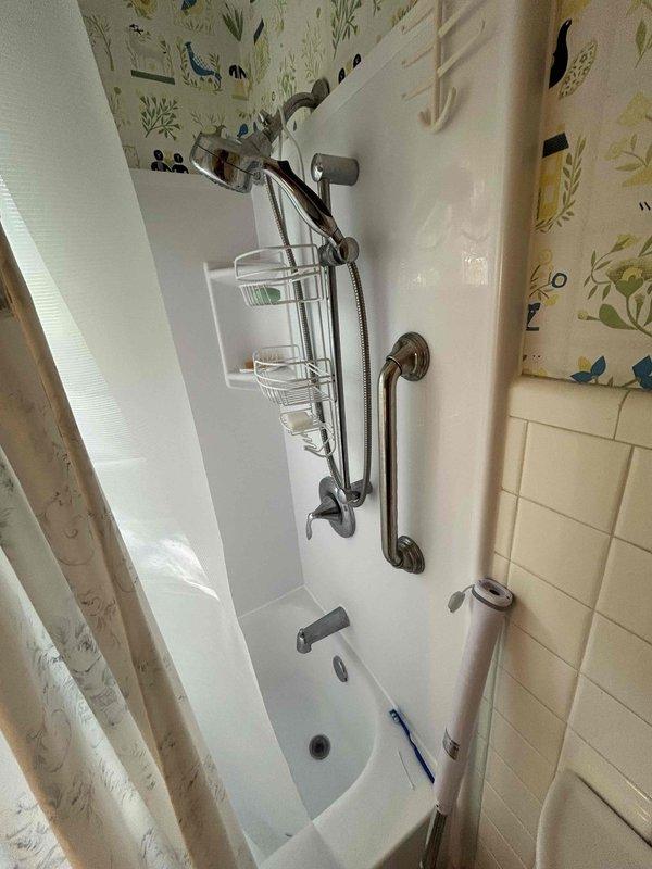 Completed comprehensive plumbing inspection including plumbing service agreement evaluation and diagnostics for reported running toilet. Inspected bathroom plumbing fixtures, tub and shower assembly with rail-mounted combination showerhead system, under-sink plumbing configuration with garbage disposal unit, braided stainless steel supply lines, PVC drainage system with P-trap assembly, and shut-off valves to ensure proper operation and identify any maintenance needs.