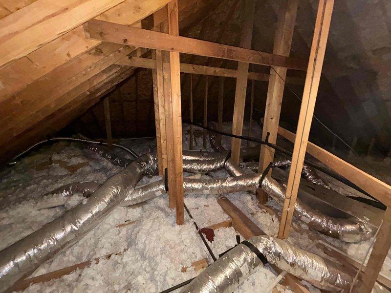 Responded to callback for recently installed system experiencing inadequate cooling performance with 5-degree temperature differential between setpoint and actual indoor temperature. Verified thermostat readings and reviewed customer-documented temperature logs spanning 6-hour period showing unit unable to maintain 74-degree setpoint during moderate outdoor conditions (87-91 degrees). 

Inspected attic installation including ductwork routing, insulation integrity, and system connections as documented in photos. Evaluated flexible duct runs for proper support, compression issues, and airflow restrictions throughout attic space. Checked all duct connections at plenum and register boots for air leakage.

Addressed secondary issue with downstairs unit where indoor blower motor operated normally but outdoor condensing unit produced humming noise without compressor engagement. Diagnosed failed run capacitor preventing compressor startup. Replaced defective dual-run capacitor with proper micr