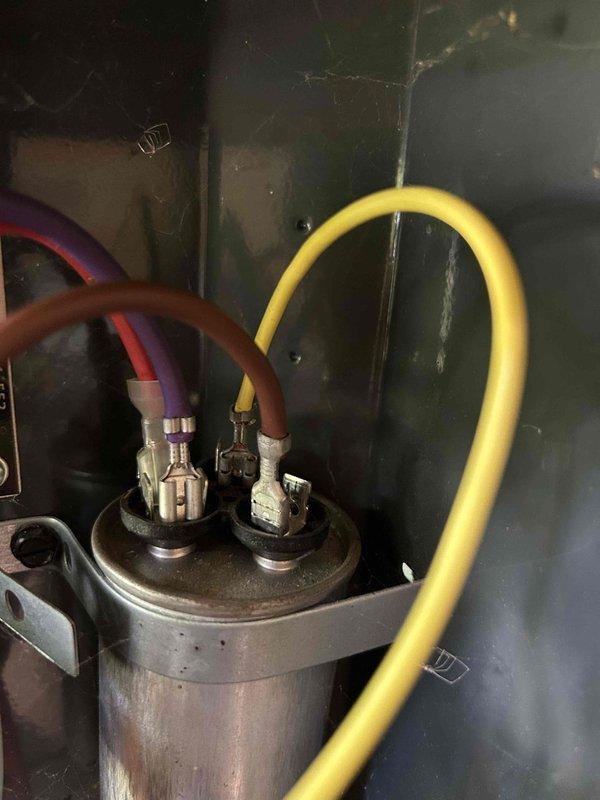 Responded to no cooling call on 10-year-old electric HVAC system with no airflow and indoor temperature at 80 degrees. Upon arrival, performed diagnostic testing of outdoor unit components using clamp meter, which revealed amperage reading of 46.2 amps at compressor. Inspected refrigerant line connections, capacitor, and electrical control board wiring. Identified system failure preventing compressor operation and airflow circulation. Documented equipment condition with photos showing outdoor unit internal components, refrigerant line connections with brass fittings, and electrical measurements during troubleshooting process.