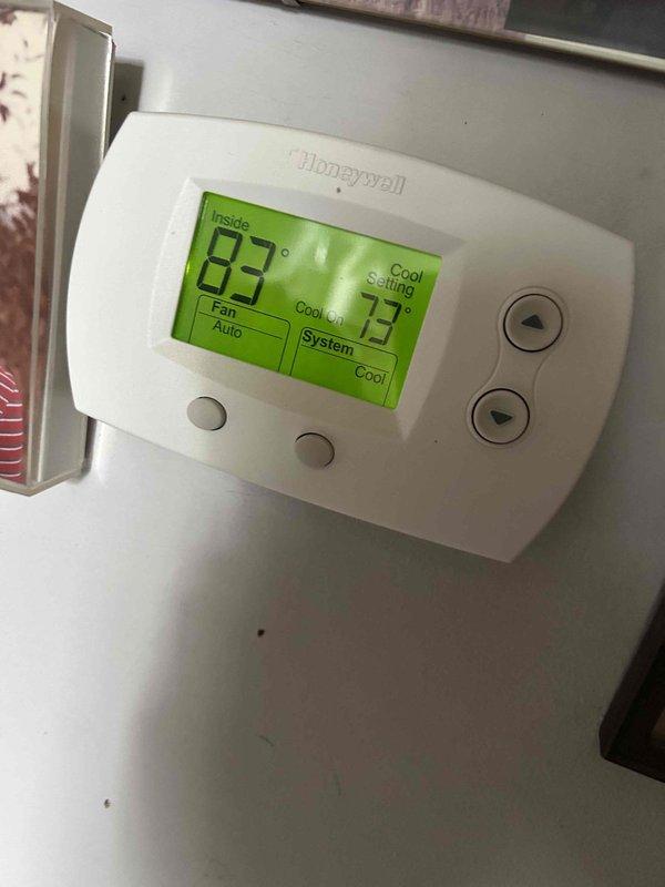 Responded to no-cooling call on 12-year-old Lennox system. Upon arrival, confirmed indoor blower operational but outdoor condensing unit not running with condenser fan blade stationary. Thermostat displayed 83°F actual temperature with 73°F setpoint, indicating 10-degree temperature differential. Inspected indoor air handler, verified clean air filter in place and proper airflow. Checked electrical connections at thermostat showing proper cool mode command signal. Diagnosed failed outdoor unit with non-operational compressor and condenser fan, likely due to capacitor failure or compressor lockout on aging system beyond typical service life expectancy.
