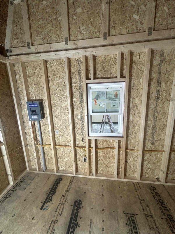 Completed full electrical installation for 12x20 commercial outbuilding over two service visits including rough-in and finish work. Installed 100-amp main service panel with three breakers for 120V, 115V, and HVAC circuits. Wired and mounted one GFCI receptacle, three duplex receptacles, one weatherproof receptacle with cover at entry doors, and one 240V 30-amp receptacle for HVAC equipment per manufacturer specifications. Installed four single-pole switches controlling four 4-foot LED strip lights, one ceiling fan with integrated lighting, and one dual-head motion-activated LED flood light centered above doorway. All installations completed to code specifications and passed final inspection.