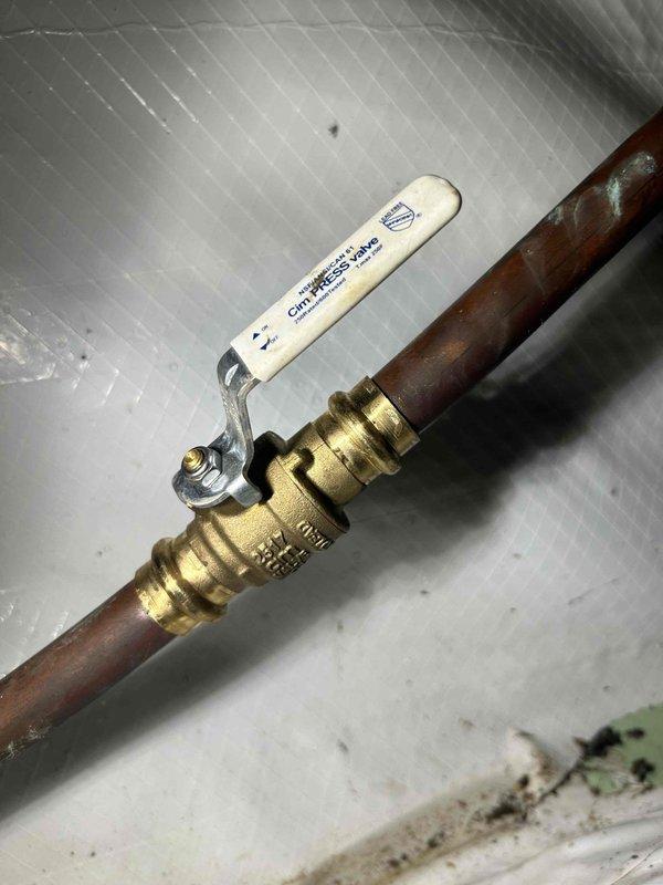 Replaced non-functioning outdoor spigot that was turning but not engaging water flow. Accessed the unit from the crawl space under the house and installed a new ball valve assembly on the copper supply line. The new valve features a brass body with threaded connections and white lever handle, restoring full functionality to the exterior water faucet.