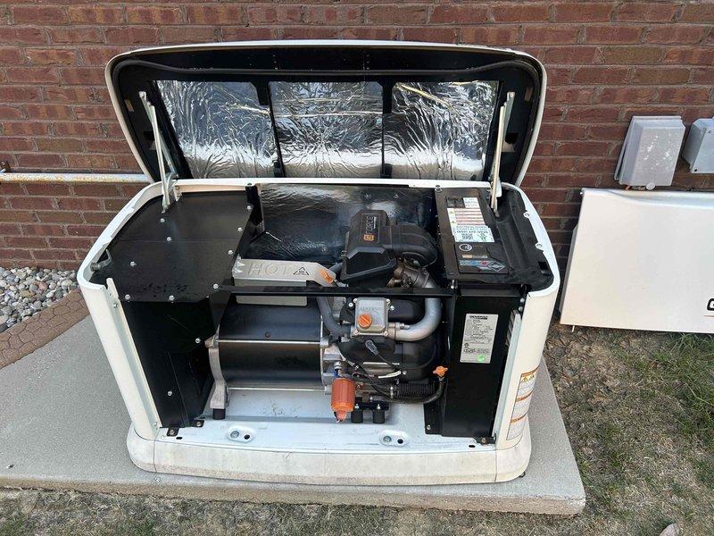 Performed routine maintenance service on a 22KW Generac standby generator unit. Conducted comprehensive inspection of all internal components including engine assembly, electrical control panels, fuel lines, and cooling systems. Verified proper operation of automatic transfer switch connections and external junction box mounting. Inspected gas supply line connections, flexible conduit routing, and PVC piping installation along exterior wall. Unit housing and concrete pad foundation found in good condition with all warning labels legible and components properly secured.