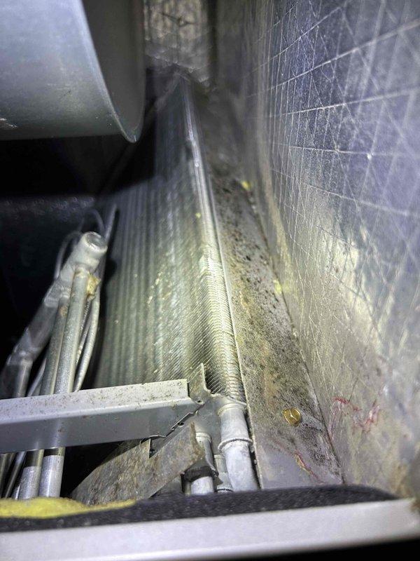 Completed Club Duo maintenance service on HVAC system. Performed comprehensive inspection of indoor air handler unit, documenting significant dust and debris accumulation on evaporator coil fins and internal components, including flexible ductwork and blower housing area. System operational at time of service completion.