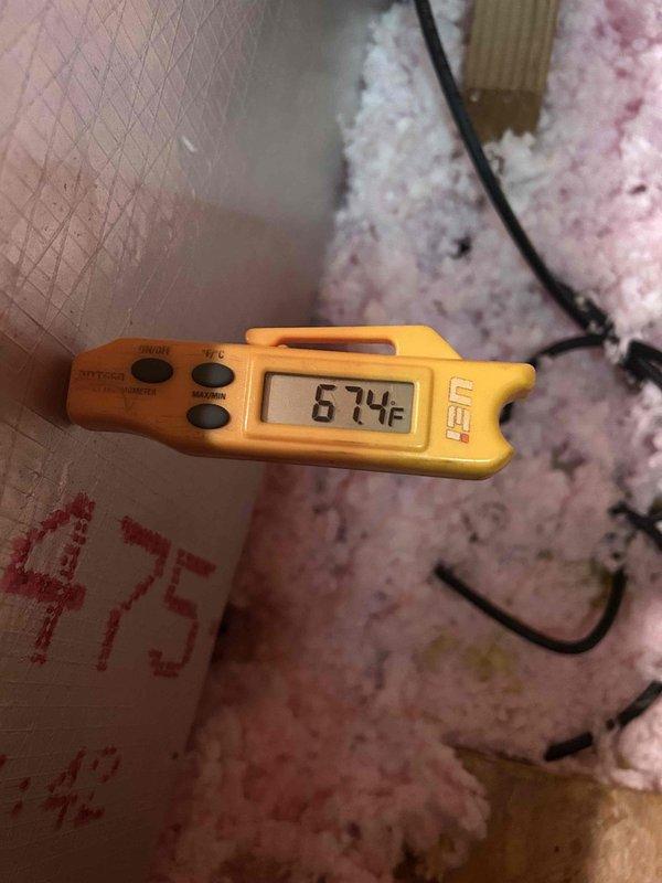 Responded to no cooling call on geothermal system with thermostat set to 68°F but reading 76°F. Performed diagnostic inspection of indoor unit located in basement and attic components. Measured supply air temperature at 67.4°F at register, indicating system is producing cool air. Inspected refrigerant lines and service valves on copper piping - all connections secure with no visible leaks. System appears to be cycling and operating within normal parameters. Previous capacitor replacement in July noted in service history. Advised on thermostat settings and system operation expectations for geothermal heat pump during peak cooling demand.