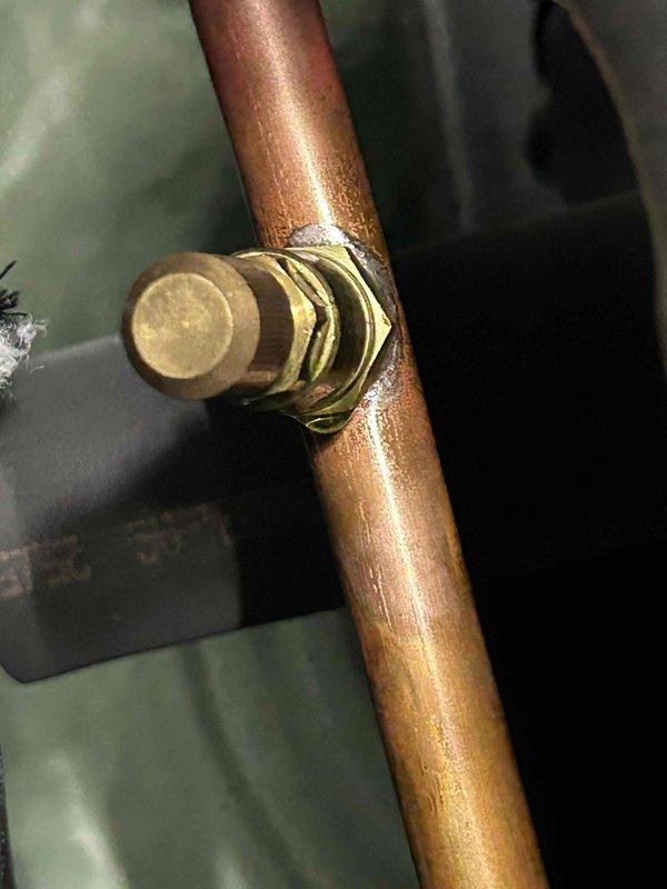 Responded to no cooling call on geothermal system with thermostat set to 68°F but reading 76°F. Performed diagnostic inspection of indoor unit located in basement and attic components. Measured supply air temperature at 67.4°F at register, indicating system is producing cool air. Inspected refrigerant lines and service valves on copper piping - all connections secure with no visible leaks. System appears to be cycling and operating within normal parameters. Previous capacitor replacement in July noted in service history. Advised on thermostat settings and system operation expectations for geothermal heat pump during peak cooling demand.