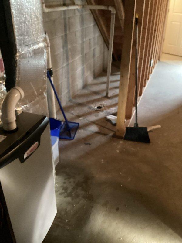 Responded to basement floor drain clog located near furnace and water heater. Upon arrival, observed standing water and puddling at drain opening, indicating blockage in drainage system. Assessed that clog was isolated to floor drain line rather than HVAC condensate system. Cleared obstruction from basement floor drain using appropriate drain cleaning equipment. Verified proper water flow and drainage upon completion. Drain now functioning normally with no standing water present.