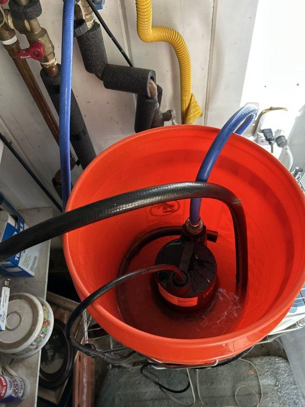 Performed routine maintenance flush on a 9-year-old gas tankless water heater located in carport. Connected circulation pump and hoses to service valves and flushed unit with descaling solution to remove mineral buildup and maintain optimal heat exchanger performance. During inspection, identified significant corrosion on copper pipe connections and fittings near the unit, indicating potential moisture exposure and oxidation over time. Completed flush cycle, verified proper flow rates, and documented corroded plumbing components for future repair consideration.