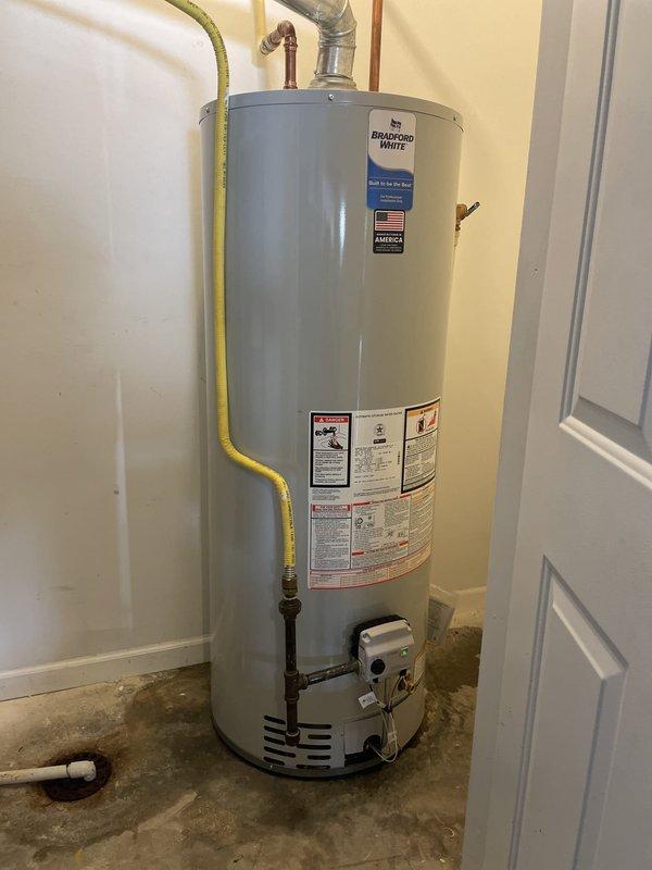 Removed and properly disposed of existing 50-gallon residential gas water heater from utility closet. Installed new Bradford White 50-gallon gas-fired water heater in same location, connecting incoming cold water supply and outgoing hot water distribution lines with appropriate copper piping and fittings. Reconnected yellow flexible gas supply line to gas control valve and verified secure connections. Installed code-compliant metallic exhaust vent piping for proper combustion gas venting. Performed complete system startup, checked all connections for gas and water leaks, verified proper burner ignition and operation, and confirmed full functionality of unit before departure.