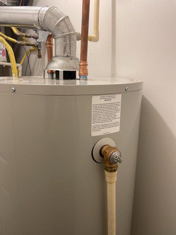 Removed and properly disposed of existing 50-gallon residential gas water heater from utility closet. Installed new Bradford White 50-gallon gas-fired water heater in same location, connecting incoming cold water supply and outgoing hot water distribution lines with appropriate copper piping and fittings. Reconnected yellow flexible gas supply line to gas control valve and verified secure connections. Installed code-compliant metallic exhaust vent piping for proper combustion gas venting. Performed complete system startup, checked all connections for gas and water leaks, verified proper burner ignition and operation, and confirmed full functionality of unit before departure.