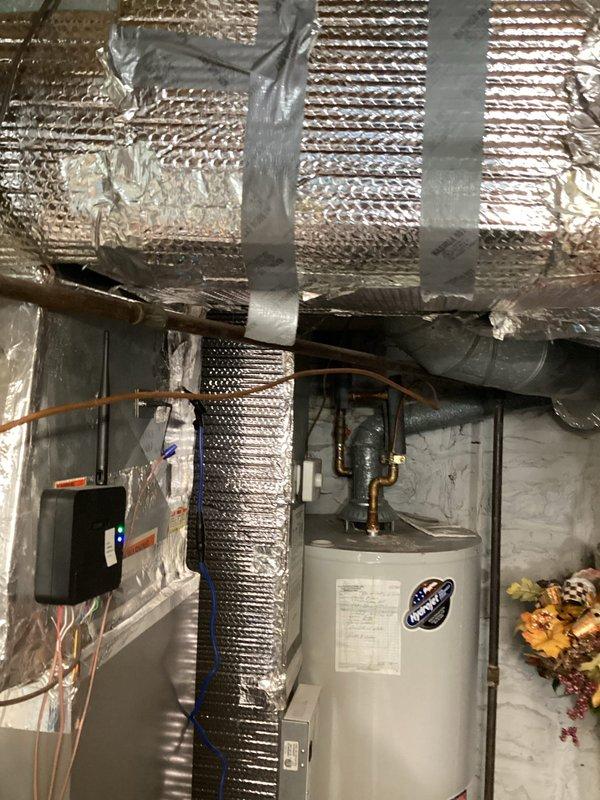 Conducted on-site assessment for tankless water heater conversion in basement utility area. Evaluated existing 50-gallon conventional tank water heater installation, documenting current plumbing connections, venting requirements, and electrical panel proximity. Photographed mechanical room layout including copper supply lines, existing HVAC ductwork clearances, and available wall space for tankless unit mounting to provide comprehensive estimate for equipment replacement and necessary infrastructure modifications.