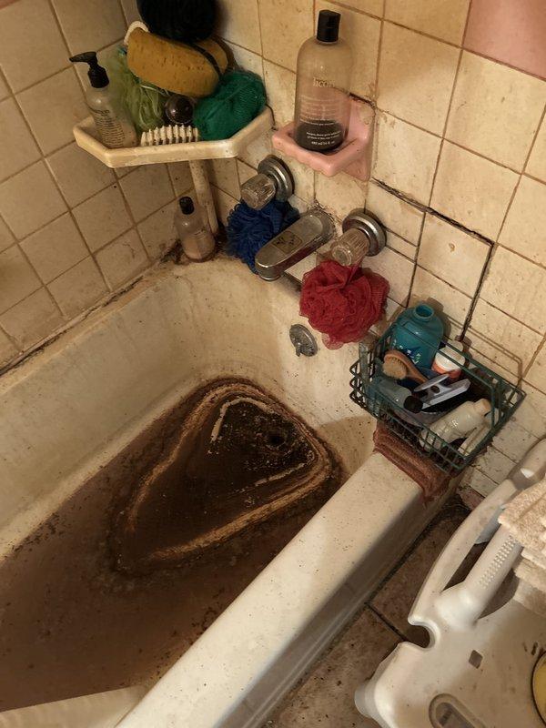 Responded to service call for clogged toilet backing up into bathtub. Upon arrival, found severe drainage blockage affecting bathroom plumbing system, with contaminated water backing up from toilet into tub basin. Cleared main drain line obstruction using professional drain clearing equipment. Restored proper drainage flow to both toilet and bathtub fixtures. Tested system to verify complete clearance and proper function of all affected fixtures.