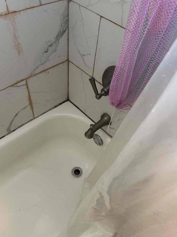 Completed routine plumbing inspection as part of maintenance plan. Inspected bathroom fixtures including toilet, bathtub, tub spout, and drain assembly for proper operation and potential issues. Documented condition of fixtures, noting grout discoloration between wall tiles and minor tile cracking in tub surround area, though all plumbing components functioning properly with no active leaks detected.