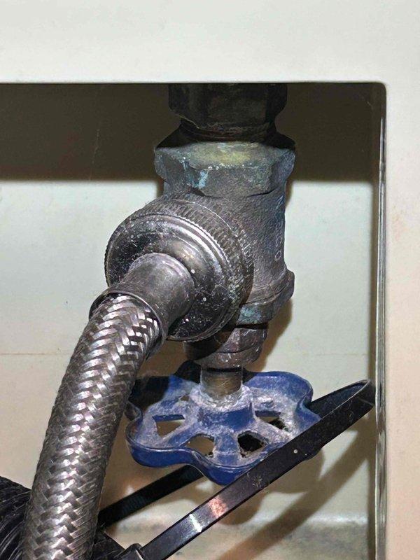 Completed comprehensive 65-point whole home plumbing inspection per preventive service agreement protocol. Conducted thorough assessment of all accessible plumbing components, fixtures, supply lines, drain systems, and shut-off valves throughout the property. Documented significant corrosion and oxidation on main water supply valve assembly, noting advanced deterioration with greenish-blue patina indicating long-term moisture exposure. Identified compromised rubber coupling on copper pipe joint showing degradation and tearing, requiring future replacement to prevent potential leaks. Observed extensive mineral buildup and oxidation on adjacent ductwork and piping. Photographed all findings for maintenance records. All observations reported to property owner with recommendations for addressing corroded components to maintain system integrity.