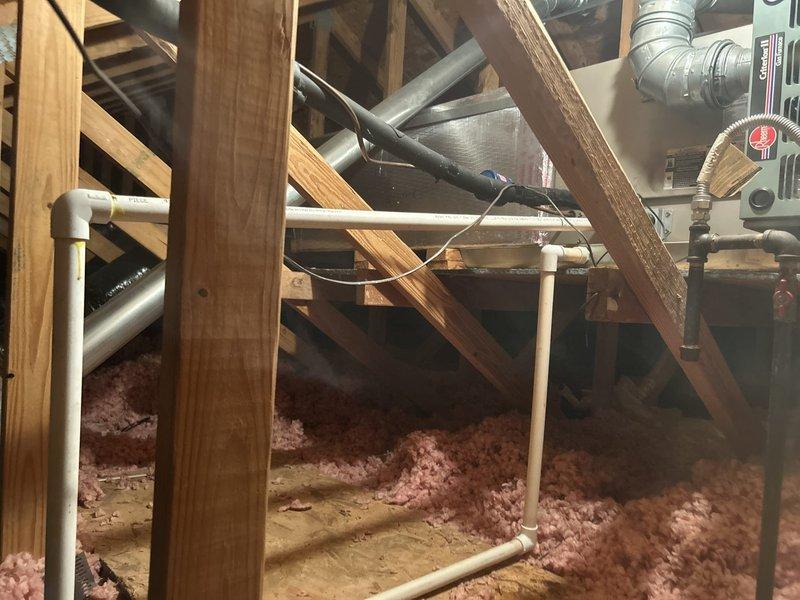 Responded to callback for recurring condensate leak in attic HVAC system. Upon inspection, located source of water intrusion at primary drain line connection point where PVC coupling had failed. Reconfigured drain line routing, installed new fittings with proper slope, and verified secondary drain line was clear and functioning. Tested system through complete cooling cycle to confirm proper drainage with no leaks detected.