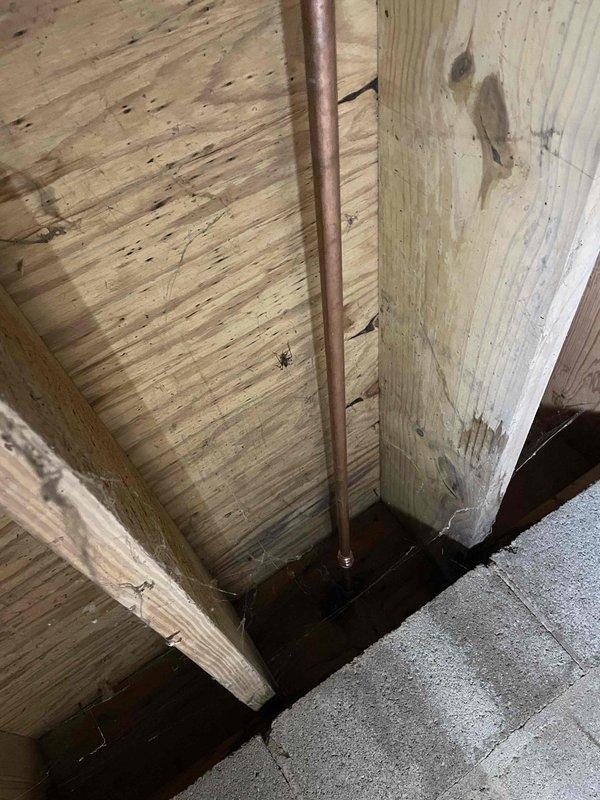 Replaced leaking outdoor spigot with new fixture after accessing the copper supply line through interior crawl space. Removed deteriorated exterior hose bib that exhibited significant oxidation and patina, then installed new frost-free sillcock to prevent future leaks and ensure proper water flow to outdoor hose connection.