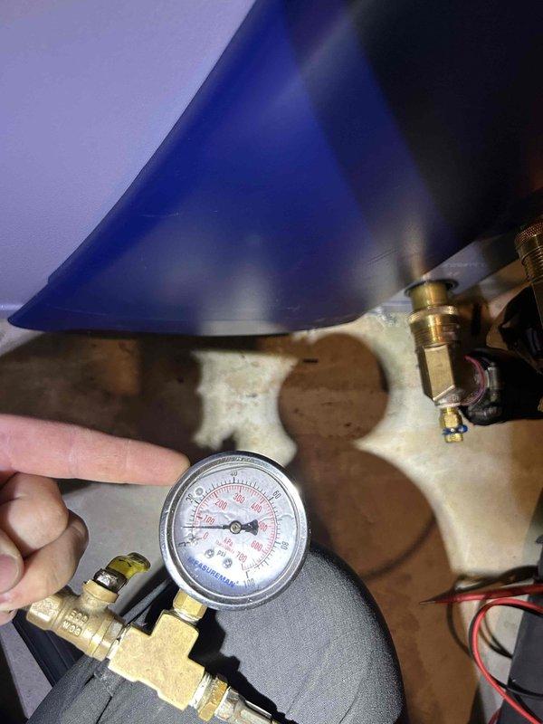 Performed maintenance inspection on dual geothermal split system with units located in attic and basement. Conducted pressure diagnostics and system performance verification on attic unit, which showed evidence of water damage and staining on exterior casing. Verified refrigerant pressures using manifold gauge set and inspected brass fittings, copper line connections, and electrical components for proper operation. Documented filter specifications as 16x25x4 for customer replacement and noted previous water intrusion affecting filter condition.