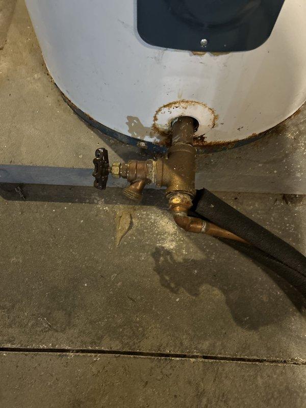 Completed installation of electric tanked water heater in basement location. Removed existing unit and installed new white tank-style electric water heater with proper plumbing connections including cold water inlet and hot water outlet piping. Connected pressure relief valve with discharge piping, installed shut-off valves, and established electrical connections to unit. All copper and flexible supply lines secured and tested for proper operation. Unit positioned on concrete floor with adequate clearance for ventilation and future maintenance access. System tested and verified for proper heating function and absence of leaks at all connection points.