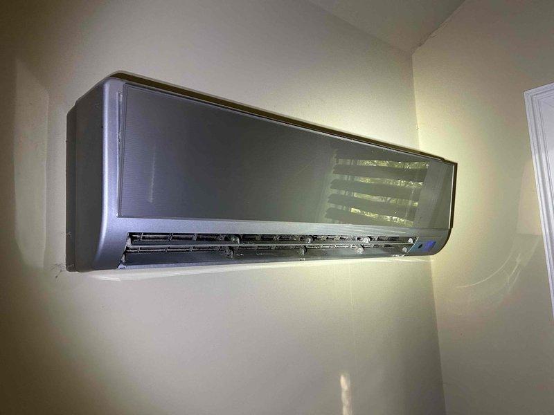 Performed comprehensive tune-up and cleaning on a 10-year-old ductless mini-split system. Removed and cleaned front panel, accessed internal blower assembly, and cleaned evaporator coil and horizontal louvers. Verified system operation with supply air temperature reading of 51.4°F, confirming proper cooling performance and airflow through the indoor unit.