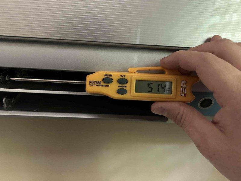 Performed comprehensive tune-up and cleaning on a 10-year-old ductless mini-split system. Removed and cleaned front panel, accessed internal blower assembly, and cleaned evaporator coil and horizontal louvers. Verified system operation with supply air temperature reading of 51.4°F, confirming proper cooling performance and airflow through the indoor unit.