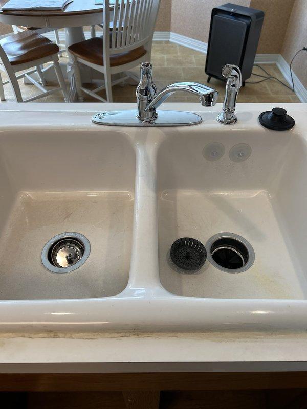 Responded to service call for non-operational garbage disposal unit. Upon arrival, assessed Whirlpool Model GC2000PE3 (1/2 HP, 120V, 60Hz, 6.9A) that was previously producing humming noise but currently had no power. Unit had been previously repaired and was of unknown age. Performed diagnostic inspection of disposal unit, electrical connections, and under-sink plumbing configuration. Documented existing installation including mounting assembly, drain connections, P-trap configuration, and electrical wiring. Photographed kitchen sink setup with double-basin configuration and complete under-cabinet plumbing system for service records.