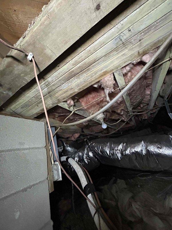 Responded to no cooling call on one-year-old electric HVAC system with flashing thermostat alert. Accessed indoor unit located in crawlspace to perform diagnostic inspection. Evaluated system components including flexible ductwork, refrigerant lines, electrical connections, and air handler assembly. Documented system configuration and current operating conditions through visual inspection of installation, including duct connections, insulation placement, and mechanical components mounted in crawlspace environment.