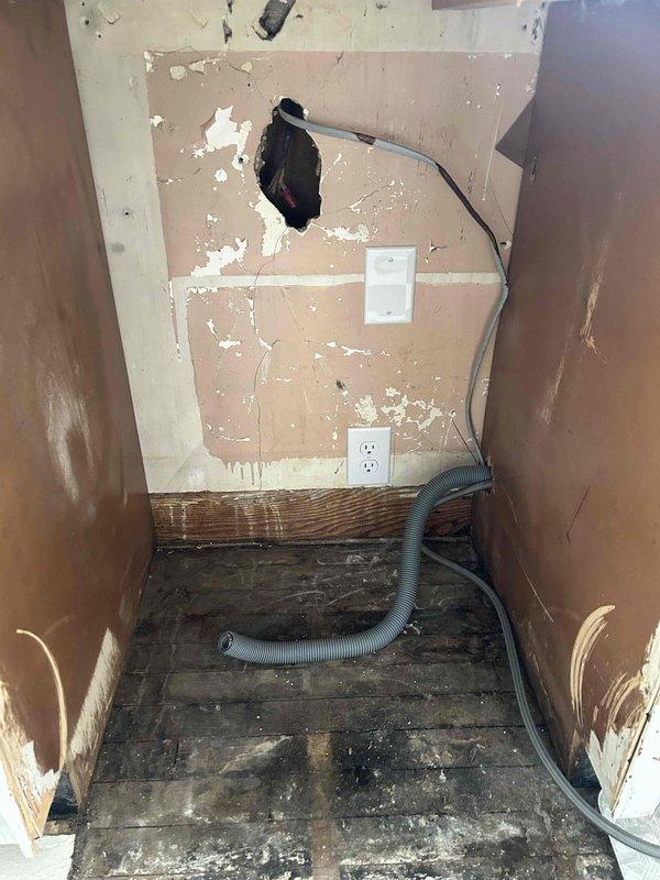 Responded to electrical service call for outlet work in interior utility space. Upon arrival, assessed existing electrical infrastructure in area showing significant wall damage and deterioration. Evaluated exposed wiring and existing outlet configurations on damaged drywall surfaces. Documented pre-existing conditions including compromised wall surfaces, exposed conduit, and deteriorated flooring materials that required consideration for safe electrical installation. Verified electrical connections and mounting locations for outlet installations, ensuring proper clearances and code compliance despite challenging wall conditions. Completed photographic documentation of work area before and during service for quality assurance and safety records.