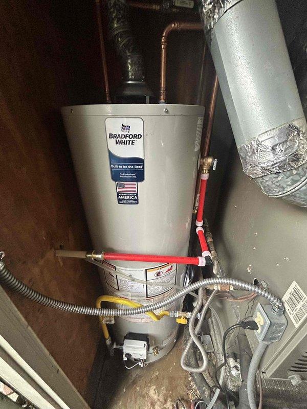 Responded to water heater leak in utility closet where existing 2018 unit had discharged majority of tank contents. Removed failed water heater and installed new Bradford White tanked water heater. Connected all copper supply lines, installed new flexible gas connector, and verified proper venting. Tested all connections for leaks, confirmed proper ignition and burner operation, and verified hot water delivery to fixtures throughout home.