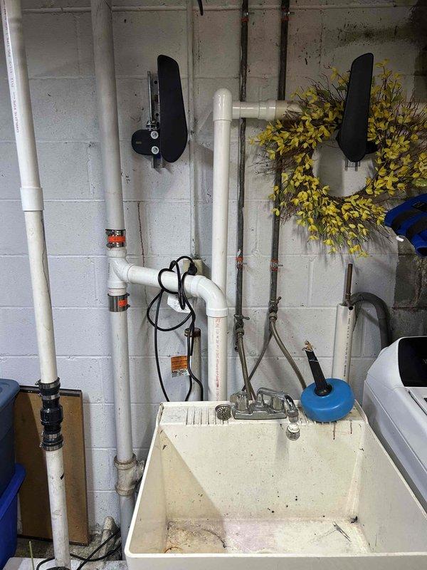 Installed new bucket pump to service existing washing machine and utility sink in basement area. Rerouted sump pump discharge line to exterior of building using white PVC piping with proper mounting brackets secured to concrete block walls. Verified all plumbing connections, tested pump functionality, and inspected system for leaks prior to completion. All components operational and watertight upon departure.
