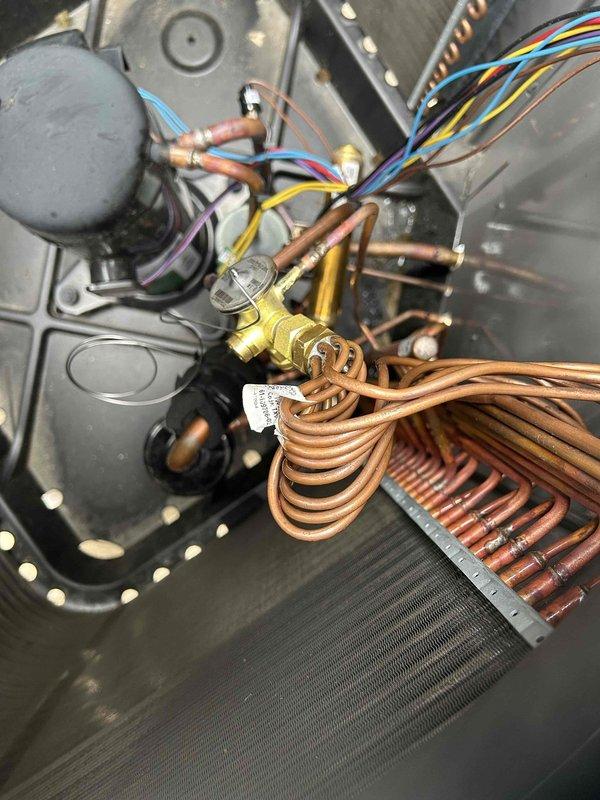 Completed first-year warranty repair on outdoor unit by replacing defective thermostatic expansion valve (TXV) and recharging system with 7 pounds of R-454B refrigerant. System tested and verified operating within manufacturer specifications upon completion.
