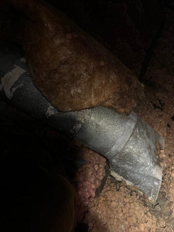 Responded to water leak complaint with moisture dripping from supply vent in upstairs area. Inspected attic space and located source of condensation at flexible ductwork connection point where deteriorated insulation jacket and inadequate sealing allowed warm, humid air contact with cold duct surface. Documented condition of aged ductwork system showing compromised insulation and loose connections at rigid elbow fitting, which created ongoing condensation issue during cooling operation.
