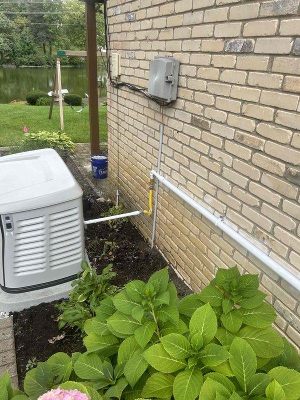 Installed approximately 40 feet of 1 1/4" black iron gas piping to supply a new standby generator. Routed piping along the lower exterior wall of the structure, securing it with appropriate pipe straps per code requirements. Applied white paint to the exposed gas line to match the existing building aesthetics. Installed yellow-handled gas shut-off valve for emergency isolation. All work completed in accordance with local gas fitting codes and manufacturer specifications for the generator installation.