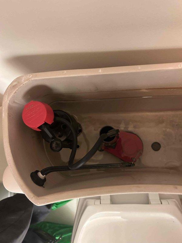 Responded to plumbing leak investigation originally identified by HVAC technician. Inspected bathroom fixture above affected area to determine source of water intrusion. Performed visual inspection of toilet and surrounding plumbing components, including removal of toilet tank lid to examine internal flush valve assembly, flapper mechanism, and fill valve for signs of leakage or malfunction. Documented conditions of toilet bowl, tank interior, and visible plumbing connections. Mineral deposits and water staining observed in tank interior consistent with normal use patterns.