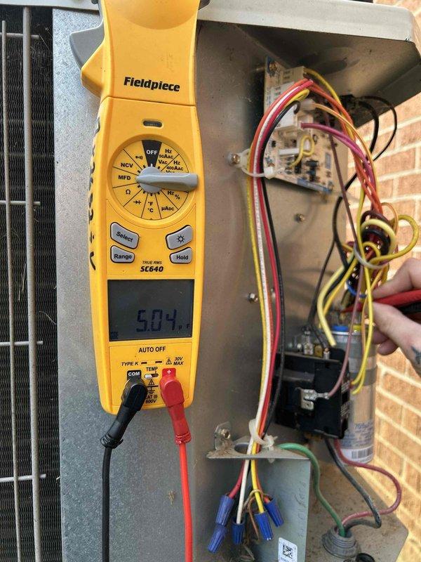 Completed comprehensive Care Plan tune-up on heat pump and air handler system located in basement. Performed electrical diagnostics using digital multimeter, measuring voltage and amperage at the outdoor unit's disconnect box and contactor assembly, confirming all readings within manufacturer specifications at 50.4V and 18.54V respectively. Inspected all electrical connections, wiring, and control components for proper operation and safety compliance.