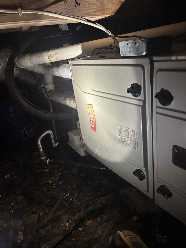 Completed full residential HVAC system replacement in crawlspace installation, removing and disposing of existing equipment. Installed Bryant 97% efficiency gas furnace (Model 916SA48060M17), 2-ton air conditioning condensing unit (Model GA5SAN52400W), and 2-ton evaporator coil (Model CVAMA2417XMA) with digital thermostat. 

Navigated equipment through confined crawlspace using PVC pipe sections as rollers to protect equipment and facilitate transport. Connected furnace to existing flue piping with proper venting and installed flame rollout protection. Installed flexible gas line connector with gas shutoff switch and electrical shutoff switch per code requirements. Added transition to evaporator coil with standard-sized air filter rack.

Outdoor installation included setting condensing unit on equipment pad, installing electrical whip kit and disconnect box, and running insulated refrigerant lines between indoor and outdoor components. Charged system with refrigerant and verified prope