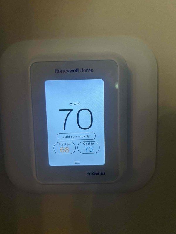 Completed second of two scheduled maintenance visits under care plan agreement. Performed comprehensive tune-up on air conditioning system and gas furnace unit located in basement. Verified 16x25x1 filter size for future service needs. Inspected Honeywell Home ProSeries thermostat displaying proper operation at 70°F with 57% humidity reading and confirmed heat/cool setpoints functioning correctly. Examined air handler unit in attic space with installed Air Scrubber air purification system showing active operation with illuminated indicator. Verified all ductwork connections, flexible duct transitions, and insulation integrity throughout system. System operating within normal parameters with no deficiencies noted.