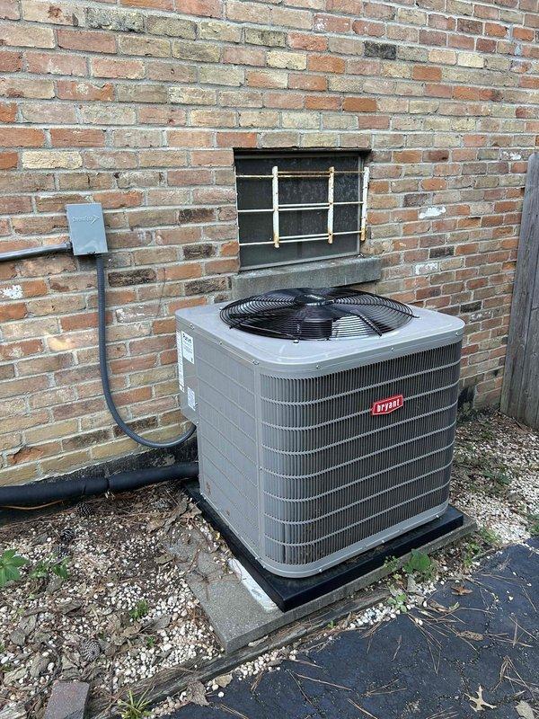 Performed comprehensive HVAC maintenance on a 20-year-old gas furnace and air conditioning system located in basement utility room. Inspected outdoor condenser unit positioned against building exterior, verified proper operation of compressor and fan motor, and confirmed adequate clearance around unit. Examined indoor gas furnace components, verified burner ignition and flame characteristics showing proper combustion, inspected heat exchanger tubes and associated copper refrigerant lines for integrity. Customer declined filter replacement and will provide their own filter for future maintenance.