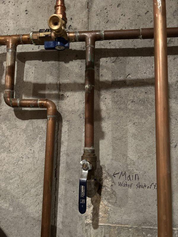 Responded to service call for basement sink and toilet backing up with drainage issues. Upon inspection, located and documented the main water shut-off valve system with copper piping configuration and verified proper operation of shut-off controls. Examined under-sink plumbing connections including PVC drain lines and garbage disposal unit to assess drainage system integrity and identify potential blockage points in the main drain line.