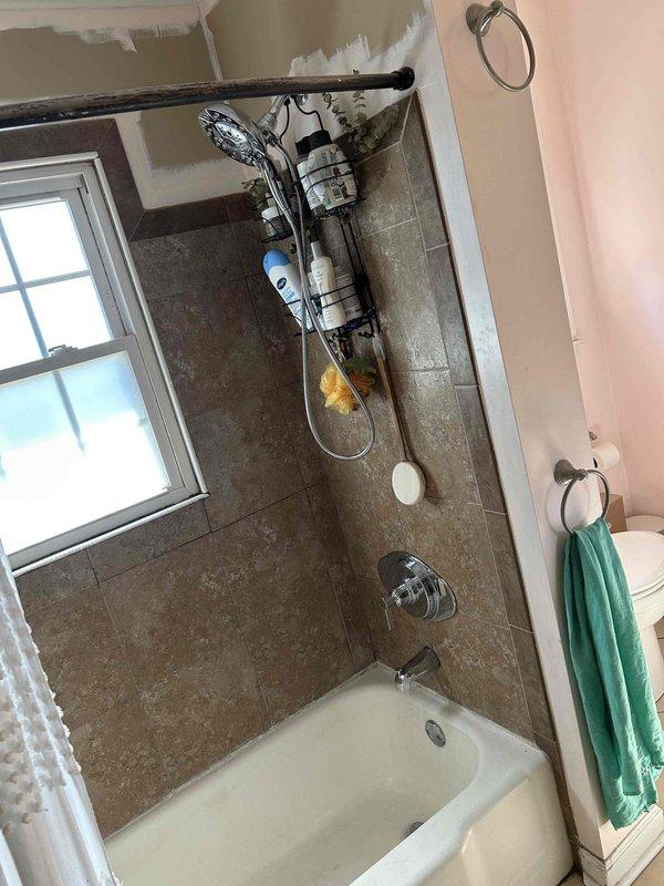 Removed existing shower valve by accessing the plumbing from behind the toilet through the wall. Installed customer-supplied shower valve and trim kit, connecting new copper supply lines to the main water system. Tested installation for proper operation and verified no leaks at connections.