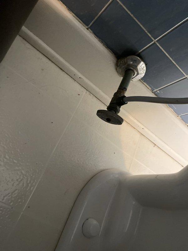 Responded to service call for leaking toilet on upper level. Upon inspection, identified corroded pipe fittings and connections in the bathroom plumbing system causing water seepage. Documented existing conditions including deteriorated metal connectors with significant rust buildup at junction points and aging pipe infrastructure requiring attention to prevent further water damage.