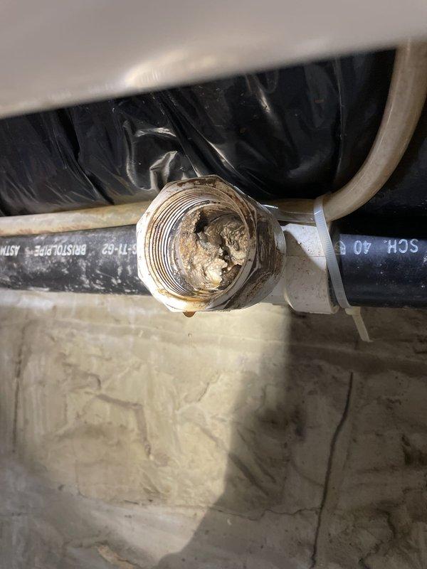Responded to service call for clogged kitchen sink. Upon arrival, performed diagnostic assessment of drainage system. Inspected under-sink plumbing connections and discovered significant buildup and corrosion within pipe fittings and drainage components. Observed active water leakage from threaded union fitting, indicating compromised seal integrity. Noted mineral deposits and dark staining throughout interior pipe surfaces, consistent with long-term accumulation and restricted water flow.

Disassembled affected plumbing connections to access clog location. Cleared blockage from drainage line and removed accumulated debris from pipe interior. Addressed corroded threaded fitting showing deterioration and water seepage. Cleaned mineral deposits from connection points to ensure proper sealing upon reassembly. Verified all flexible hoses and rigid pipe connections for structural integrity and proper alignment.

Reassembled plumbing components with secure threaded connections. Tested draina