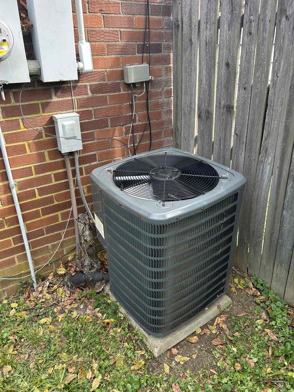 Responded to no cooling complaint on 4-year-old Goodman split system with electric air conditioning and gas furnace. Upon arrival, found outdoor condensing unit with compressor short cycling - unit would start then immediately shut down. Indoor air handler blowing warm air only.

Performed visual inspection of outdoor unit and discovered significant debris accumulation in condensate drain pan area surrounding compressor. Multiple layers of leaves and organic matter had collected around base of compressor and throughout service area. Debris was restricting airflow and creating potential for system contamination.

Inspected condenser coil and found fins partially blocked with environmental buildup and dark coating from prolonged exposure. Checked refrigerant lines showing normal oxidation patina consistent with age. Verified electrical connections and wiring to compressor - all connections secure with no visible damage.

Removed accumulated leaf litter and organic debris from drain pan a