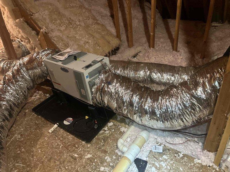 Installed two customer-supplied Honeywell Elite Pro 1200 thermostats and customer-supplied dehumidifiers in attic space. Added secondary drain pan beneath air handling unit, installed overflow safety float switch, and completed condensate drainage system with PVC piping to prevent water damage from potential equipment leaks.