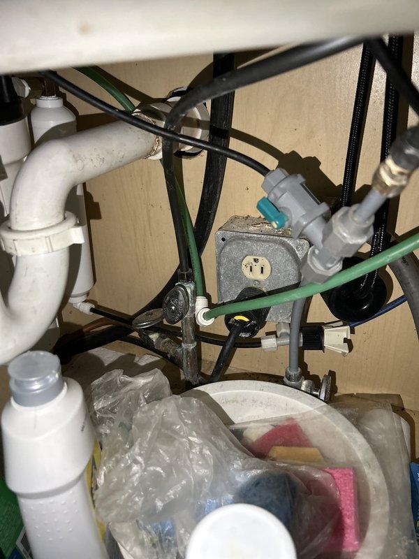 Completed comprehensive 65-point whole home plumbing inspection as requested. Inspection revealed significant corrosion and rust on main shutoff valve assembly and associated metal pipe fittings, indicating age-related deterioration that may require future attention. Under-sink plumbing system examined, including PVC drainage pipes, pump unit with auxiliary connections, and flexible supply lines, all found to be properly secured and functional at time of inspection.