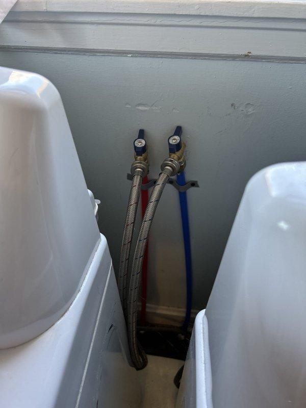 Completed washer line installation modifications and verified proper leveling of supply connections. Installed braided stainless steel flex hoses with quarter-turn ball valves featuring ergonomic handles for water supply control. Met with plumbing inspector who conducted final inspection and issued approval sticker for permit 2609-006602, confirming all work meets code requirements.