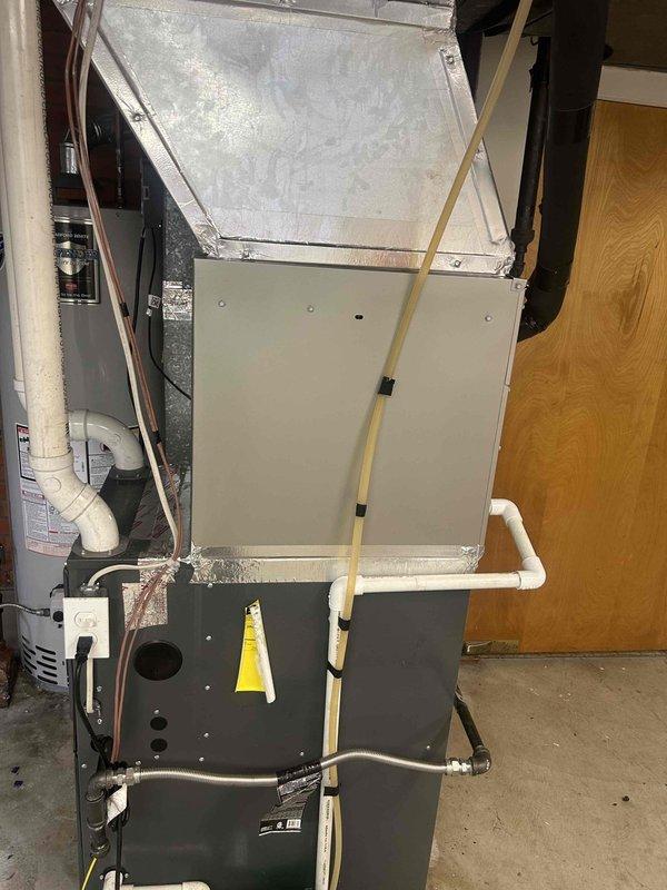 Successfully completed residential air conditioning and evaporator coil installation. Installed Bryant 3-ton up to 17 SEER2 outdoor condensing unit (model GA5SAN53602W) with new outdoor pad, electrical disconnect box, and electrical whip kit. Installed Bryant 3-ton evaporator coil (model CVAVA3617XMA) positioned on top of existing furnace. Fabricated and installed insulated supply transition from new coil to existing supply plenum using foil-backed insulation. Ran and insulated refrigerant lines with filter drier installation. Re-installed gas drip leg to code compliance. Integrated existing thermostat with new system. Installed SS2 coil drain safety water sensor and tested operation. Removed and disposed of old equipment. Verified all electrical connections, refrigerant charge, and system operation. System tested and operational upon completion.