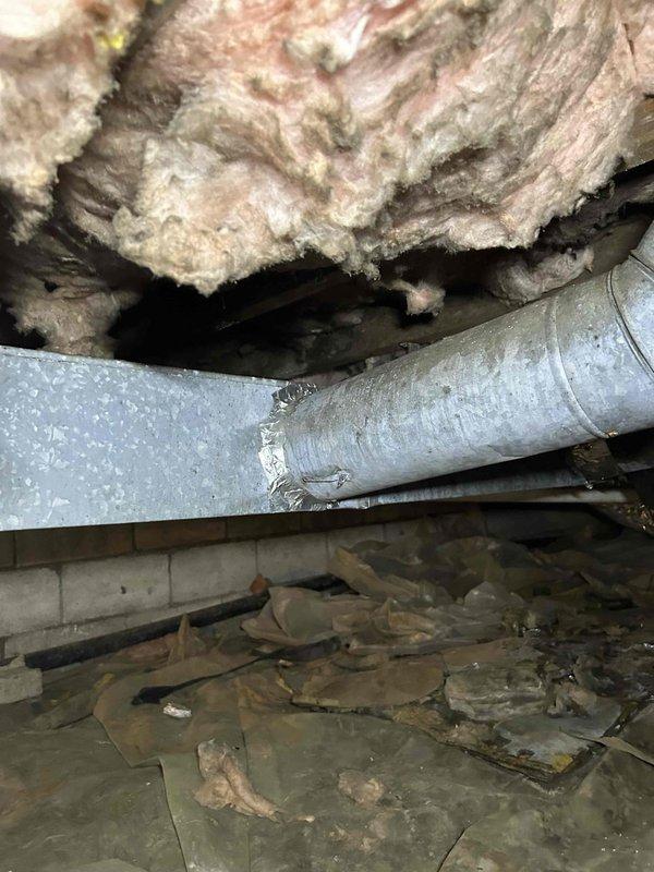 Responded to service call for ductwork repairs in crawl space. Upon inspection, identified damaged galvanized metal ductwork with compromised seams and joints requiring attention. Documented existing conditions including aged ductwork system, accumulated debris in crawl space, and insulation displacement around HVAC components. Provided detailed assessment and pricing estimate to customer for necessary ductwork repairs before proceeding with authorized work.