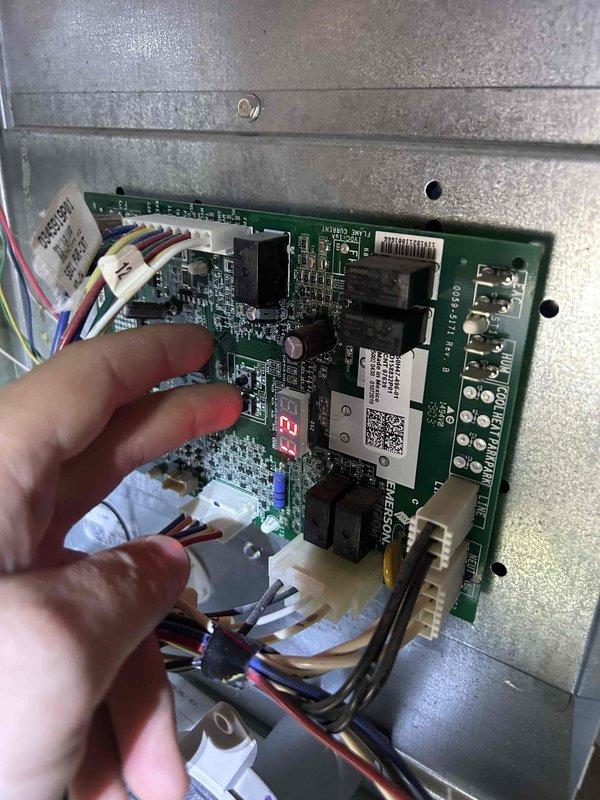 Responded to no heat call on 7-year-old gas furnace located in attic. Unit was running but blowing cold air on first heating cycle of the season. Diagnosed control board issue by inspecting electrical connections and testing current draw, which measured 1.84 amps at the time of service. Evaluated circuit board connections and wiring harnesses to identify the heating malfunction. System required further diagnostic evaluation of the control board and associated electrical components to restore proper heating operation.